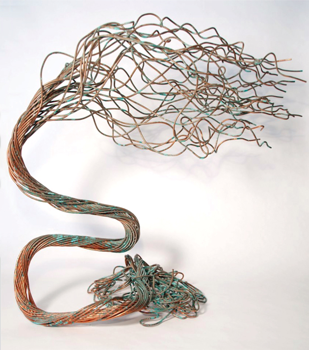 Abstract wire sculpture composed of intertwined copper strands forming a flowing, organic shape, exhibited at a Boston furniture gallery.